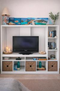 a white entertainment center with a flat screen tv at Emma's HOUSE near beach in Tsakaíoi +23 photos
