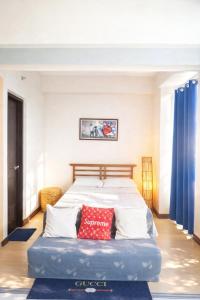 a bedroom with a bed with a red pillow on it at Mactan Newtown Deluxe 8 Boulevard Ocean View in Lapu Lapu City +30 photos
