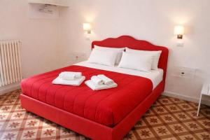 a red bed with two towels on top of it at Le Gemme Rooms in Matera