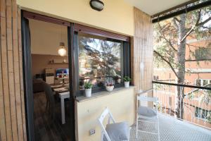 a balcony with sliding glass doors and a table at Eur Bright Spacious Terraced Apartment with private parking only for Small Cars in Rome