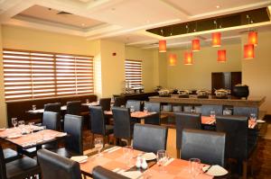 - un restaurant avec des tables et des chaises dans une salle dans l'établissement Hotel Monticello Tagaytay, à Tagaytay