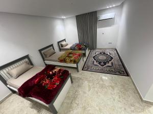 a living room with two beds and a couch at شقق الشموخ in Dammam