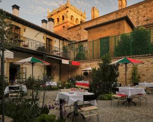 a patio with tables and umbrellas in front of a building at Eunice Hotel Gastronómico in Salamanca