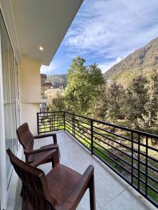 a balcony with two chairs and a view of the mountains at Soma House Dharamkot in McLeod Ganj +54 photos