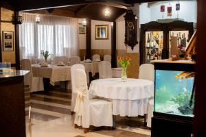 a restaurant with white tables and chairs and a fish tank at Hotel Villa Neretva - Metković in Metković
