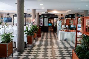 a man is standing in a restaurant with tables at Hotel Villa Neretva - Metković in Metković