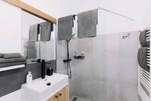 a bathroom with a white sink and a shower at Larco Trieste studio living 3 in Trieste