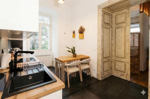 a kitchen with a wooden door and a table at Larco Trieste studio living 3 in Trieste