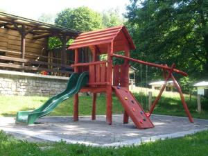 a wooden playground with a slide and a slideintend at Chatová osada Budín u Žirovnice in Žirovnice