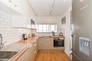 a kitchen with a sink and a refrigerator at Beach View - East Wittering in Chichester