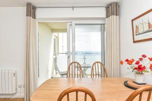 a dining room with a table and chairs and a window at Beach View - East Wittering in Chichester +9 photos