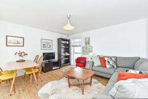 a living room with a couch and a table at Beach View - East Wittering in Chichester