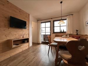 a living room with a dining room table and a television at Ferienwohnungen Vogler in Oberstdorf