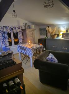 a living room with a table and a couch at Mise au vert in Saint-Juvin +6 photos