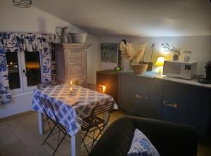 a living room with a table and a microwave at Mise au vert in Saint-Juvin