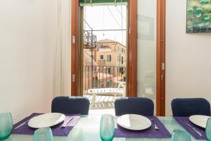 a dining room with a table and chairs and a window at Venice Altanina Apartment in Venice
