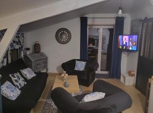 a living room with two couches and a flat screen tv at Mise au vert in Saint-Juvin