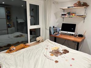 a bedroom with a bed with a computer on a desk at Baoyan Kingston - Guest House with 2 bedrooms with 1 toilet-washing room in Kingston upon Thames