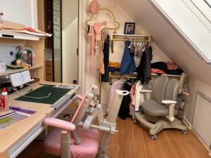 an attic room with a desk and a room with a chair at Baoyan Kingston - Guest House with 2 bedrooms with 1 toilet-washing room in Kingston upon Thames +8 photos