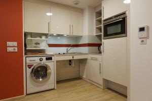a kitchen with a washing machine and a washer at Appart One Uzès in Uzès +5 photos