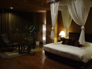 Habitación de hotel con cama y silla en Breezbay Seaside Resort Matsushima, en Matsushima