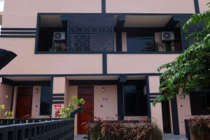 a building with two balconies with a dog in the window at Salasala Suites, Salasala, Mbezi Beach in Dar es Salaam