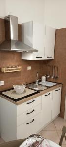 a kitchen with white cabinets and a sink at Il Cas8tto in Pozzuoli