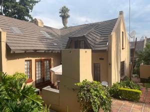 a house with a shingled roof at Lalakamnandi Guesthouse in Pretoria
