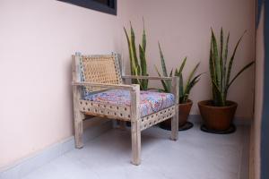 a wicker chair sitting in a room with plants at Salasala Suites, Salasala, Mbezi Beach in Dar es Salaam +10 photos