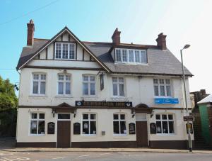 a white building on a street corner at Sandpiper Inn B&B and Pub in Ilfracombe