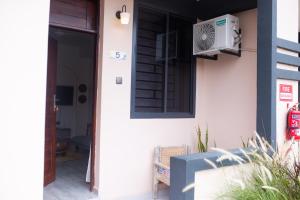 a house with a window and a air conditioner at Salasala Suites, Salasala, Mbezi Beach in Dar es Salaam