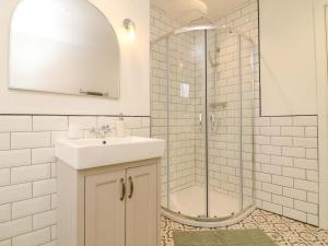 a white bathroom with a sink and a shower at Crown Cottage in Belper +9 photos