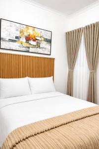 a bedroom with a bed and a painting on the wall at Bonno Guest Suite in Gaborone