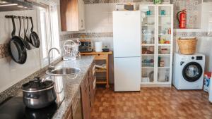 a kitchen with a sink and a white refrigerator at Casa de la Abuela - Encanto rural para grupos in Campofrío +54 photos