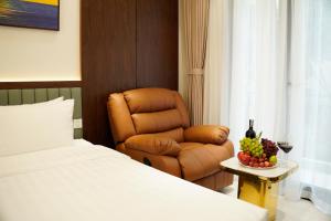 a bedroom with a bed and a chair and a bowl of fruit at Blubiz Hotel 9 in Hanoi