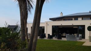 budynek ze stołami i krzesłami przed nim w obiekcie Logis Hôtel du Large w mieście Plougonvelin