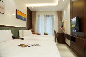 a hotel room with two beds and a television at Blubiz Hotel 9 in Hanoi