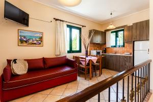a living room with a couch and a kitchen at Dukes Poolside Houses in Paralio Astros