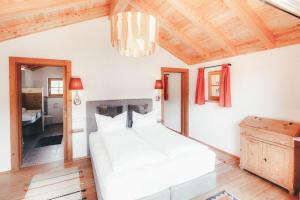 a bedroom with a white bed and a wooden ceiling at Luna Blanca Chalet in Schwangau