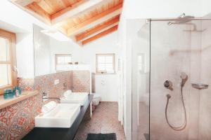 a bathroom with two sinks and a shower at Luna Blanca Chalet in Schwangau +7 photos
