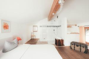 a white bedroom with a bed and a shower at Luna Mia 1 Chalet in Schwangau
