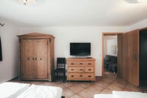 a bedroom with a tv and a wooden dresser with a tvicterictericter at Luna Mia Apartment 3 in Schwangau