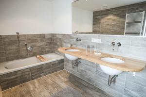 a bathroom with two sinks and a bath tub at Luna Mia Apartment 3 in Schwangau +13 photos