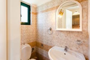 a bathroom with a toilet and a sink and a mirror at Dukes Poolside Houses in Paralio Astros +34 photos