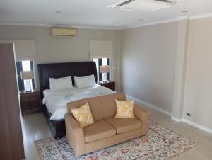 a bedroom with a bed and a couch at Origin life in Ban Na Sat