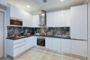 a kitchen with white cabinets and black counter tops at Scuderia il Costa in Paratico +32 photos
