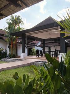 a pavilion with tables and chairs in a backyard at Origin life in Ban Na Sat
