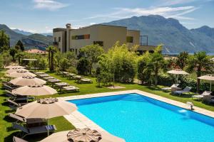 una imagen de un complejo con piscina y sombrillas en Active & Family Hotel Gioiosa en Riva del Garda