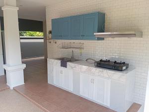 a kitchen with blue cabinets and a sink at Origin life in Ban Na Sat