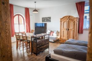 a living room with a desk and a living room with a couch at Hopfenalm in Ilmmünster